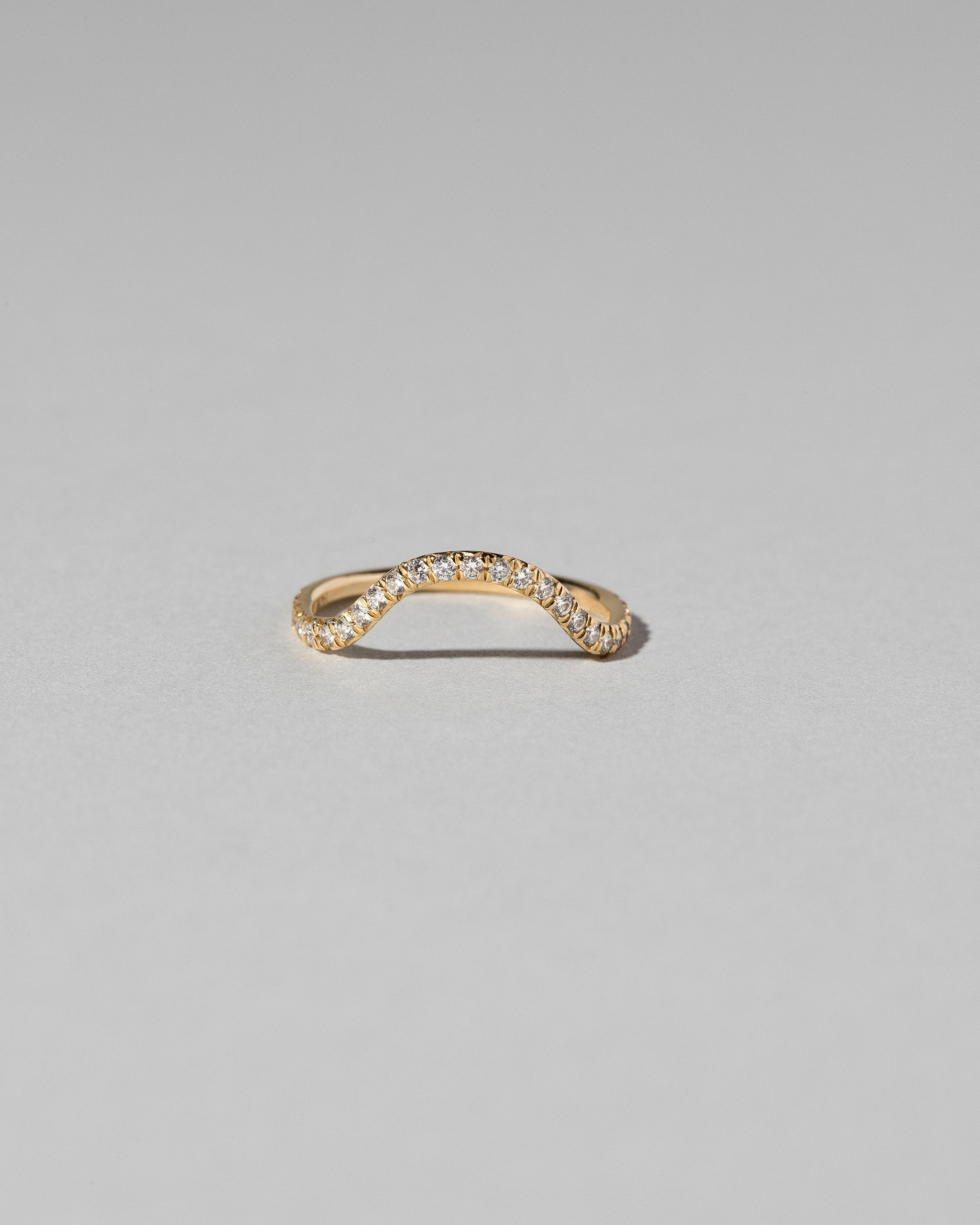 Gold Pavé White Diamond Curve Band on light color background.
