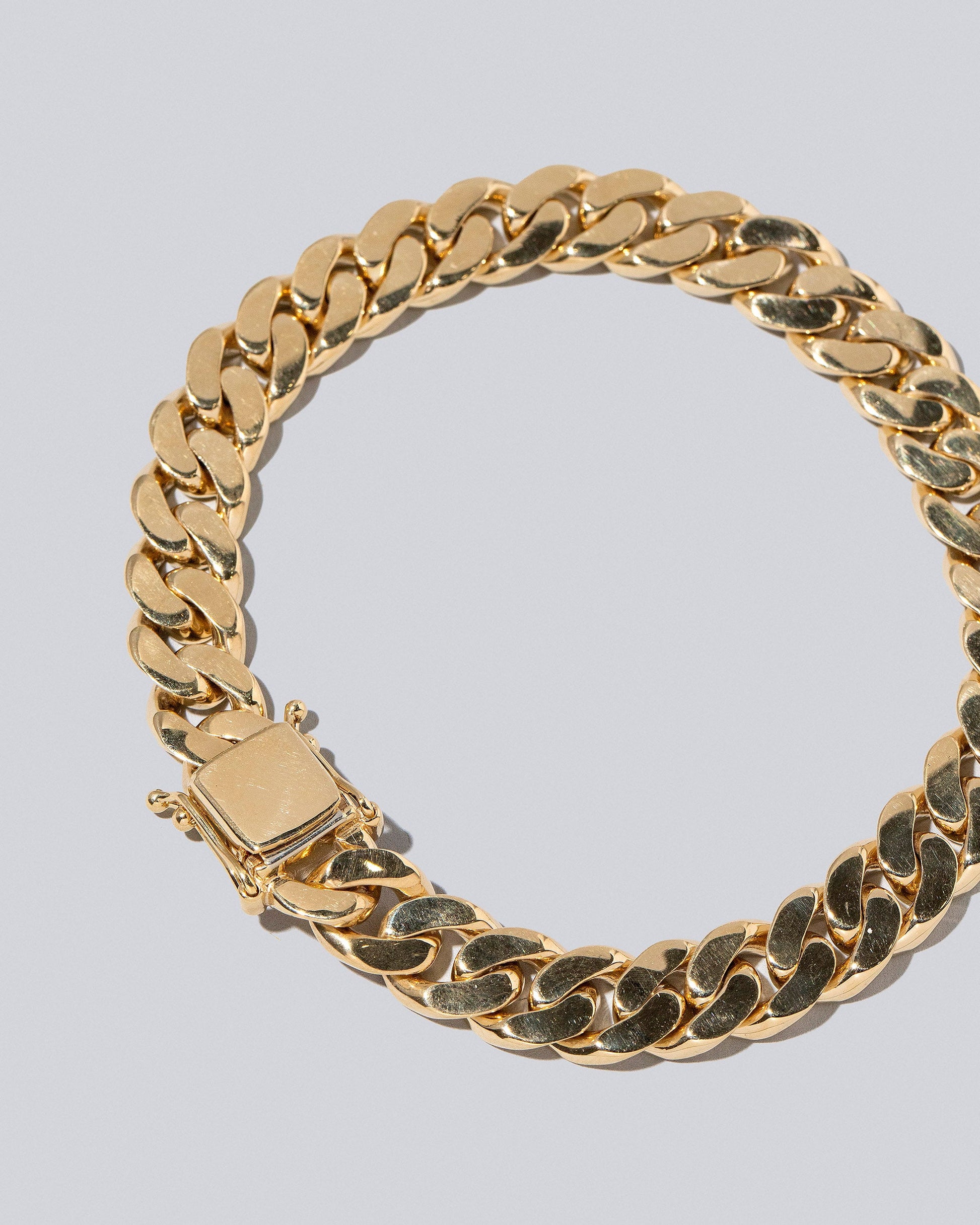 Closeup details of the 9.5mm Curb Chain Bracelet on light color background.