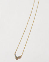 Gold Baguette Bar Necklace on light color background.