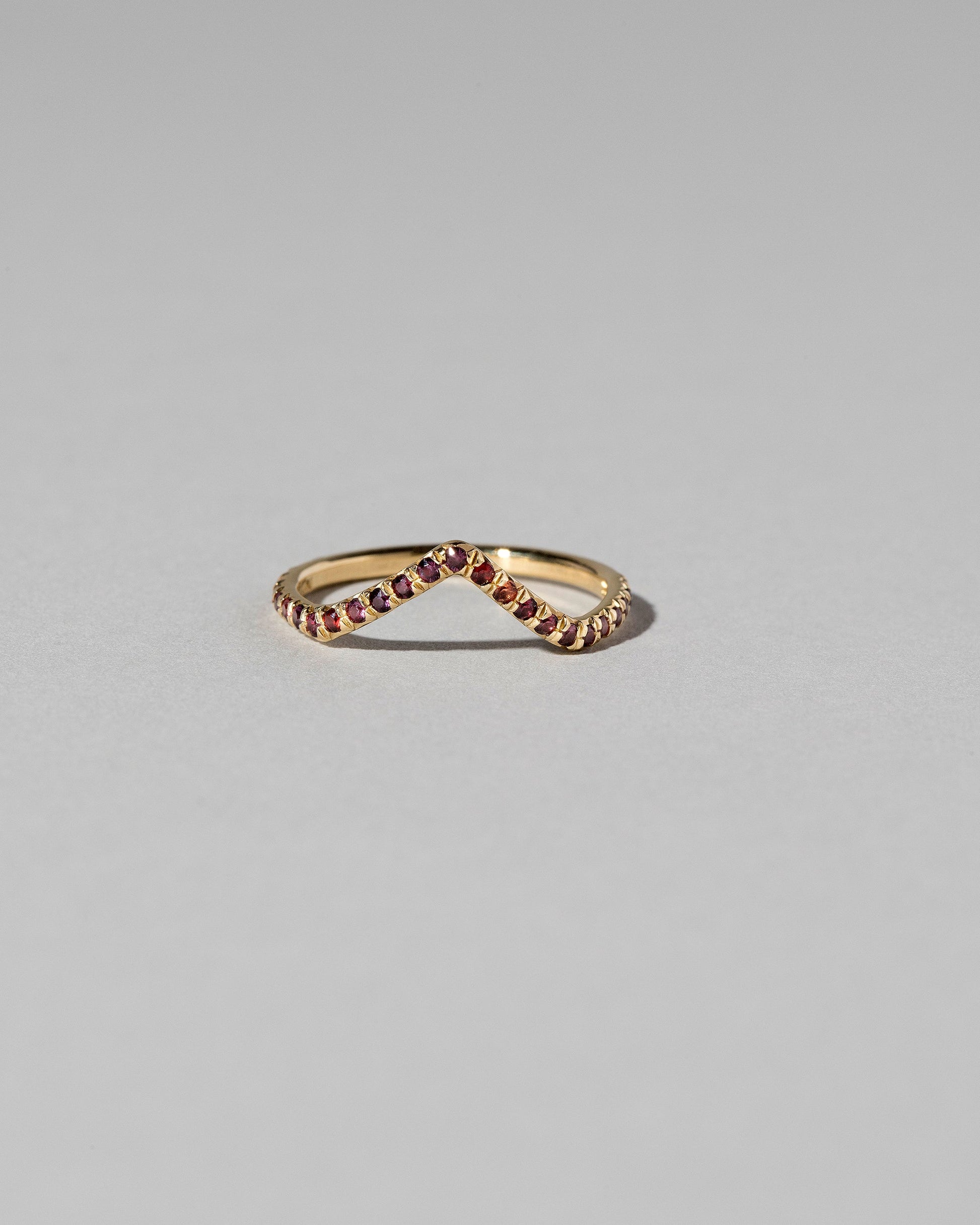 Gold Garnet Pavé High Peak Band on light color background.