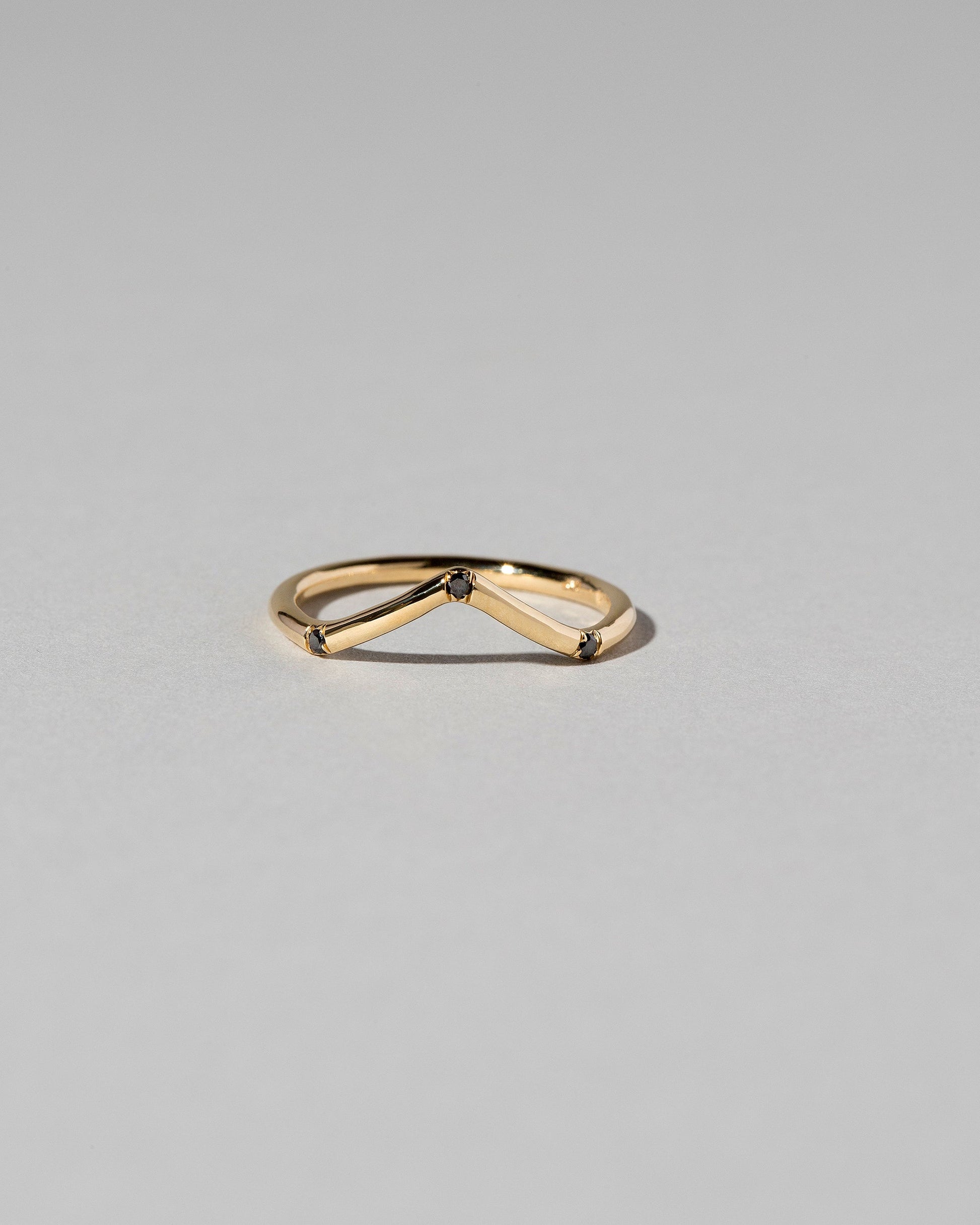 Gold Three Stone Black Diamond High Peak Band on light color background.