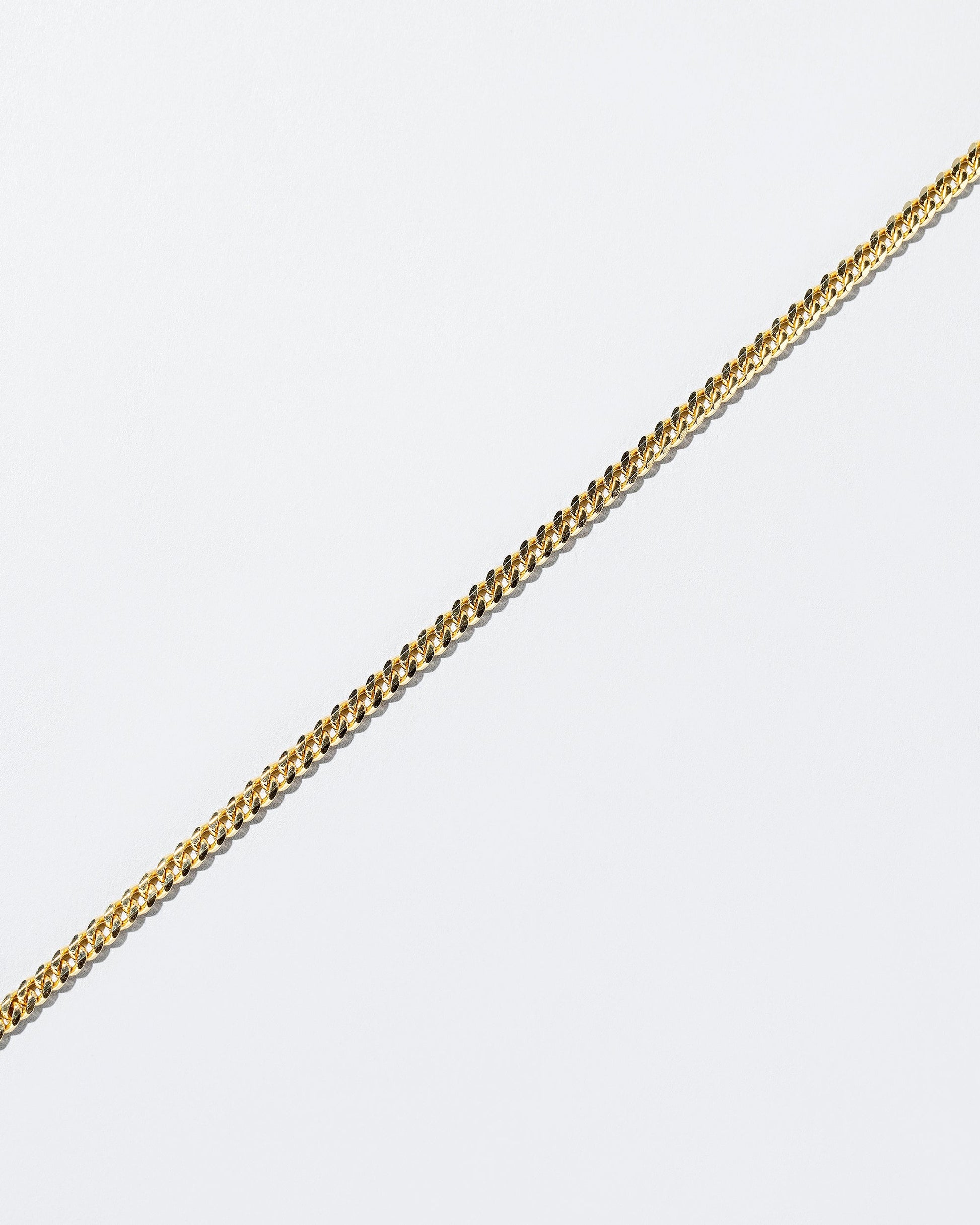 Closeup details of the 2.4mm Curb Chain Necklace on light color background.