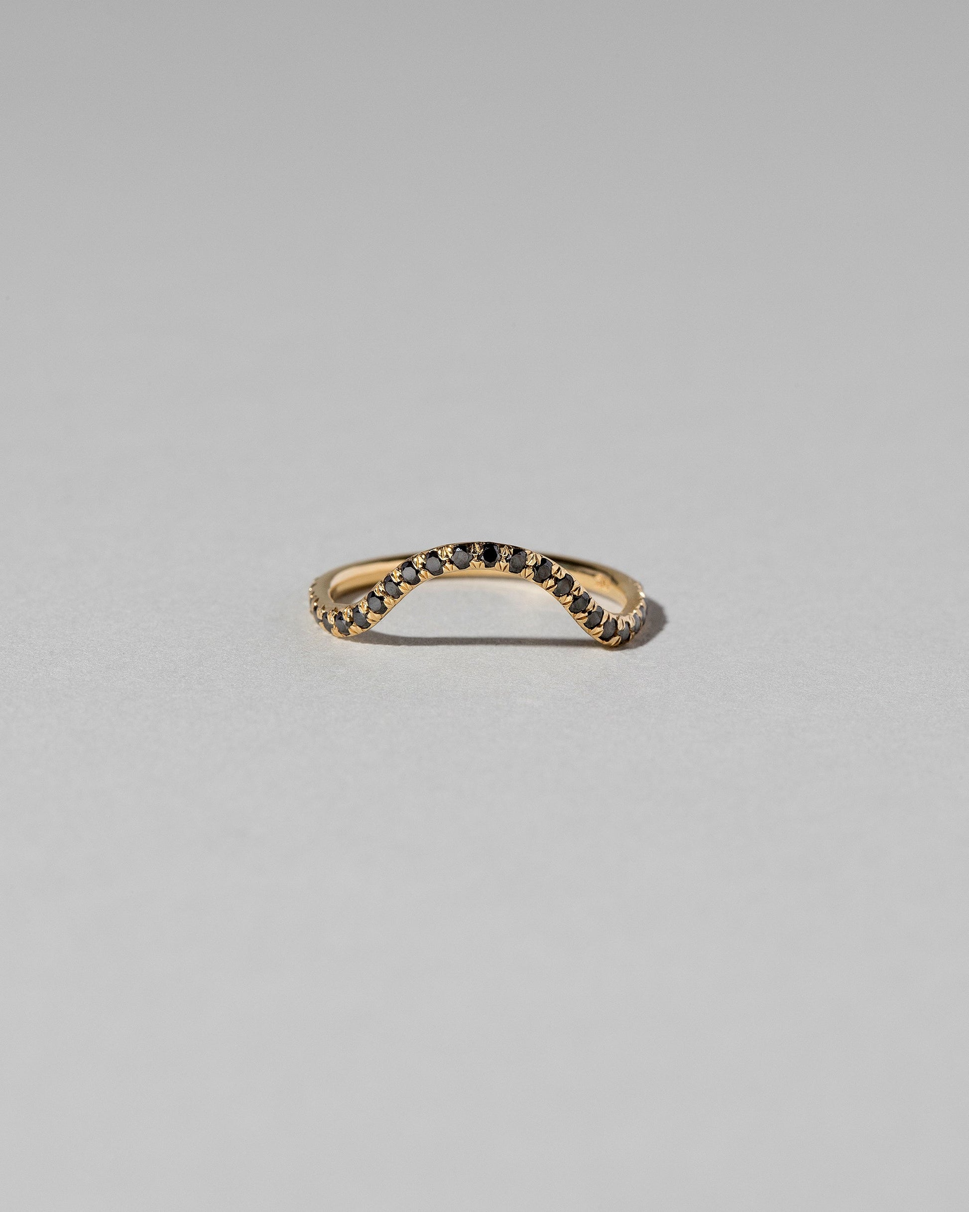 Gold Pavé Black Diamond Curve Band on light color background.