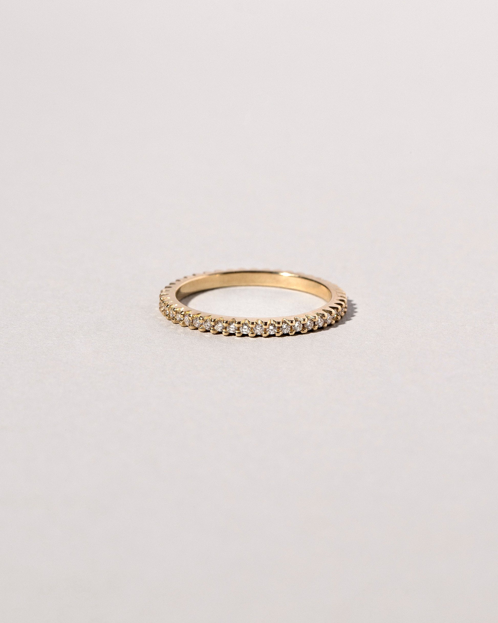 Closeup details of the Gold White Diamond Gear Edge Band on light color background.