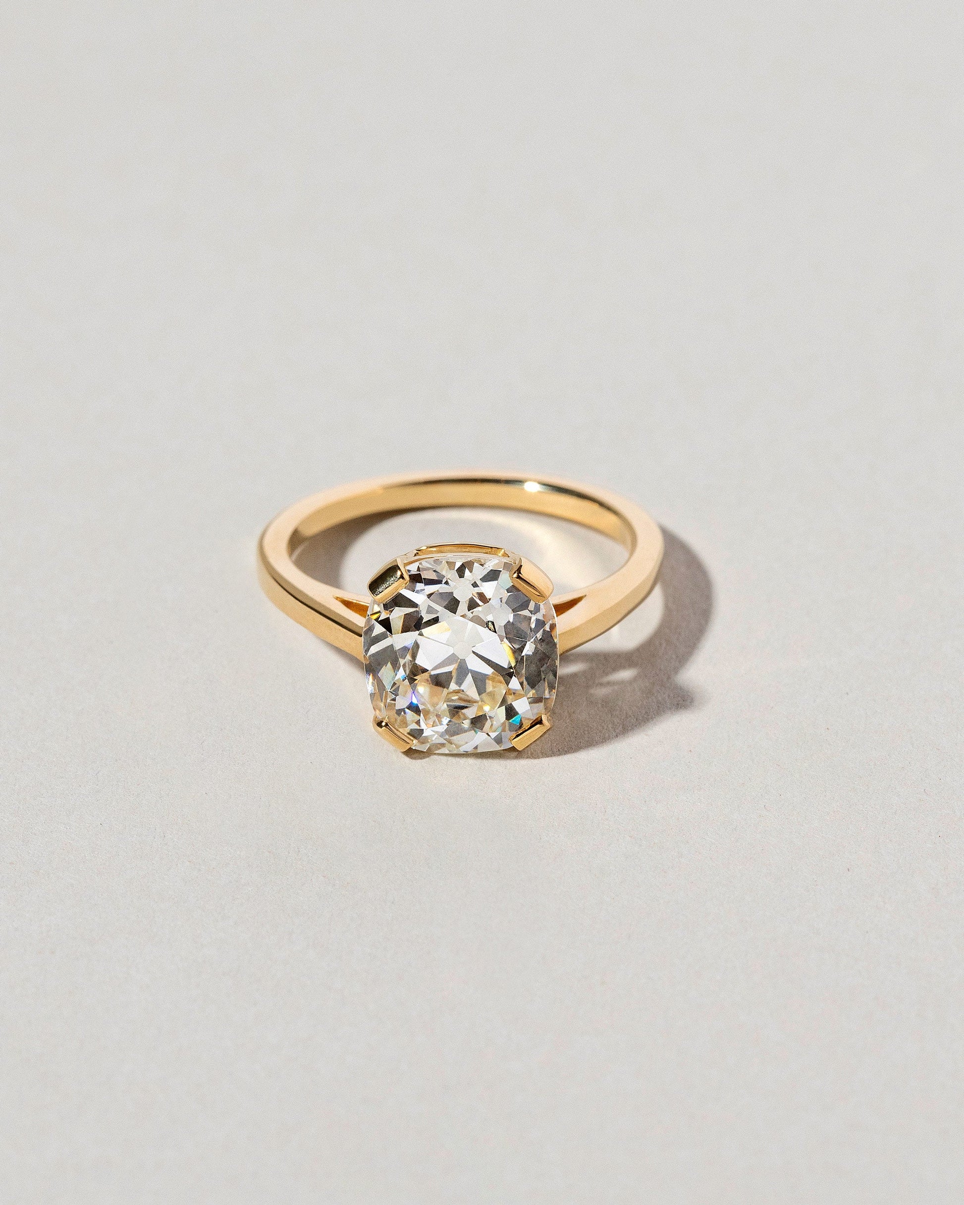 Cushion Cut Diamond Solitaire Ring on light color background.