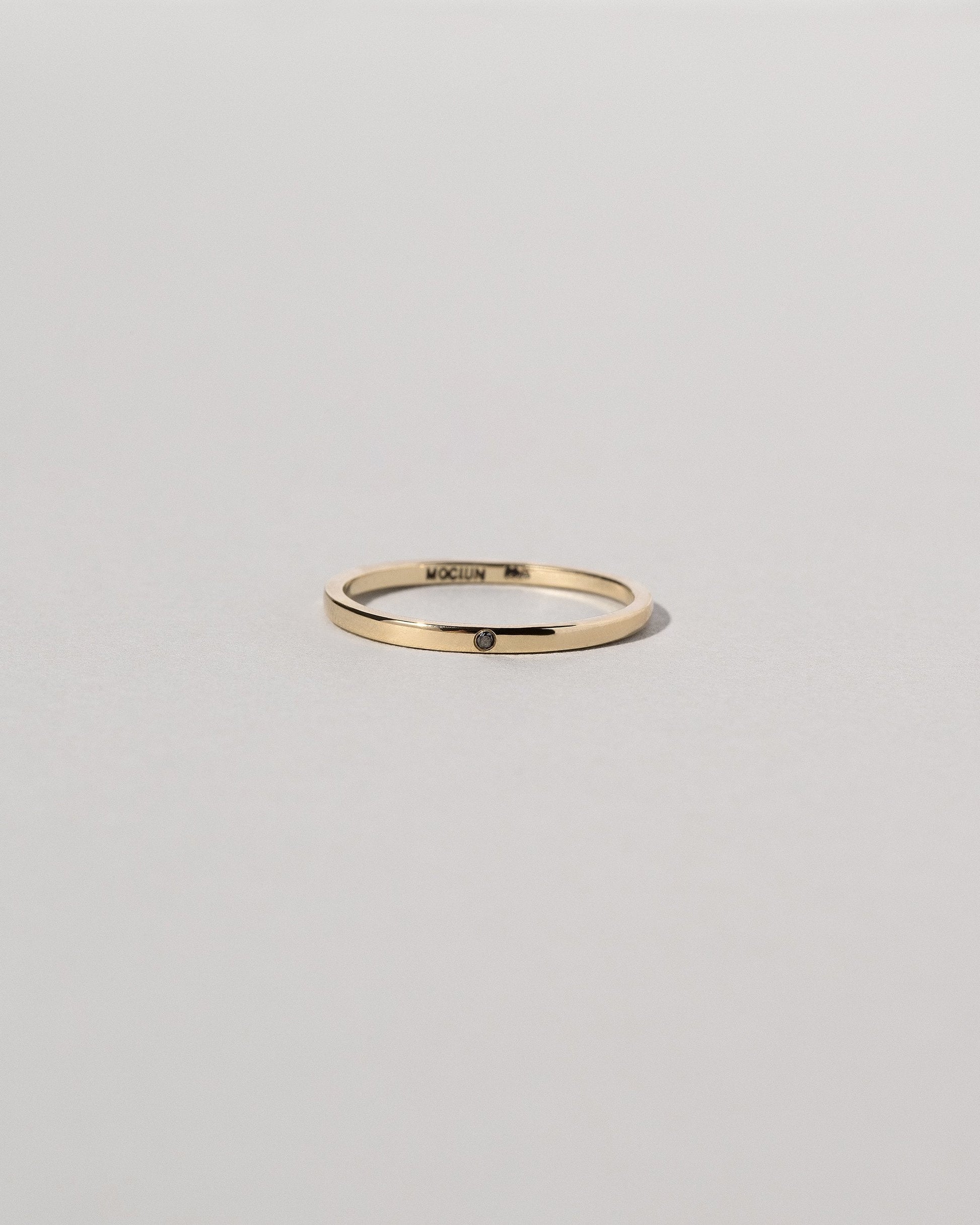 Gold 1.5mm Square Wire Band with Single Stone Black Diamond 1.3mm on light color background.