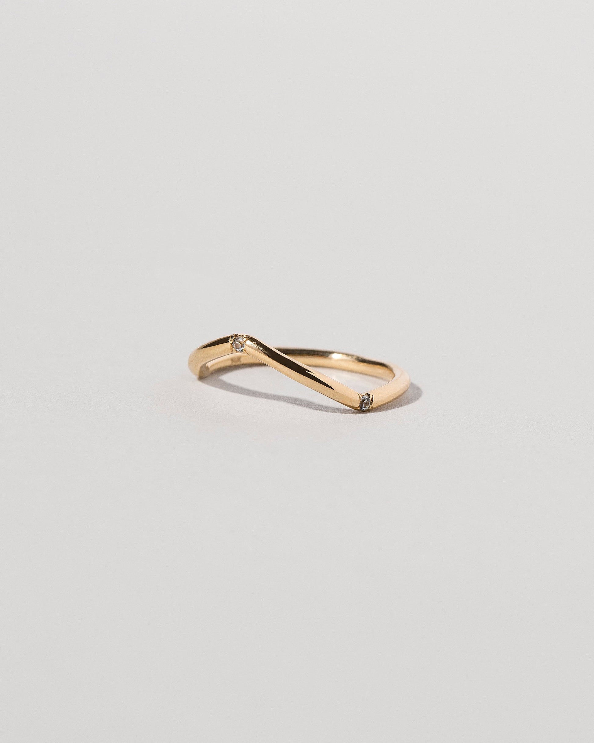 View from the side of the Gold Three Stone Blue Sapphire Low Peak Band on light color background.