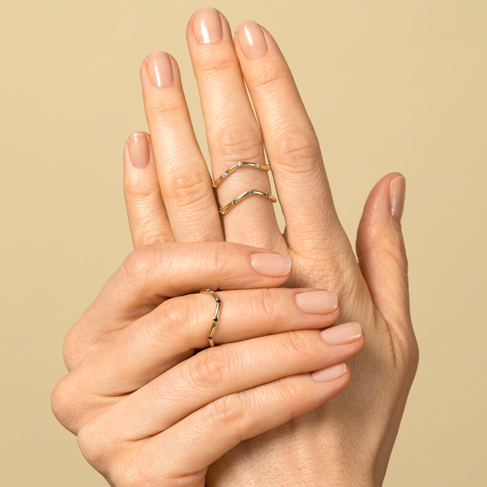 product_details::Gold Five Stone Low Peak Bands on model.