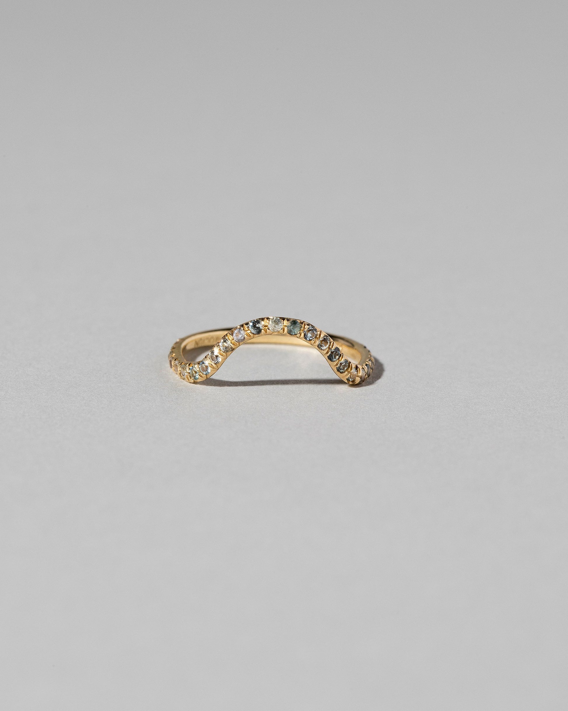 Gold Pavé Blue Sapphire Curve Band on light color background.