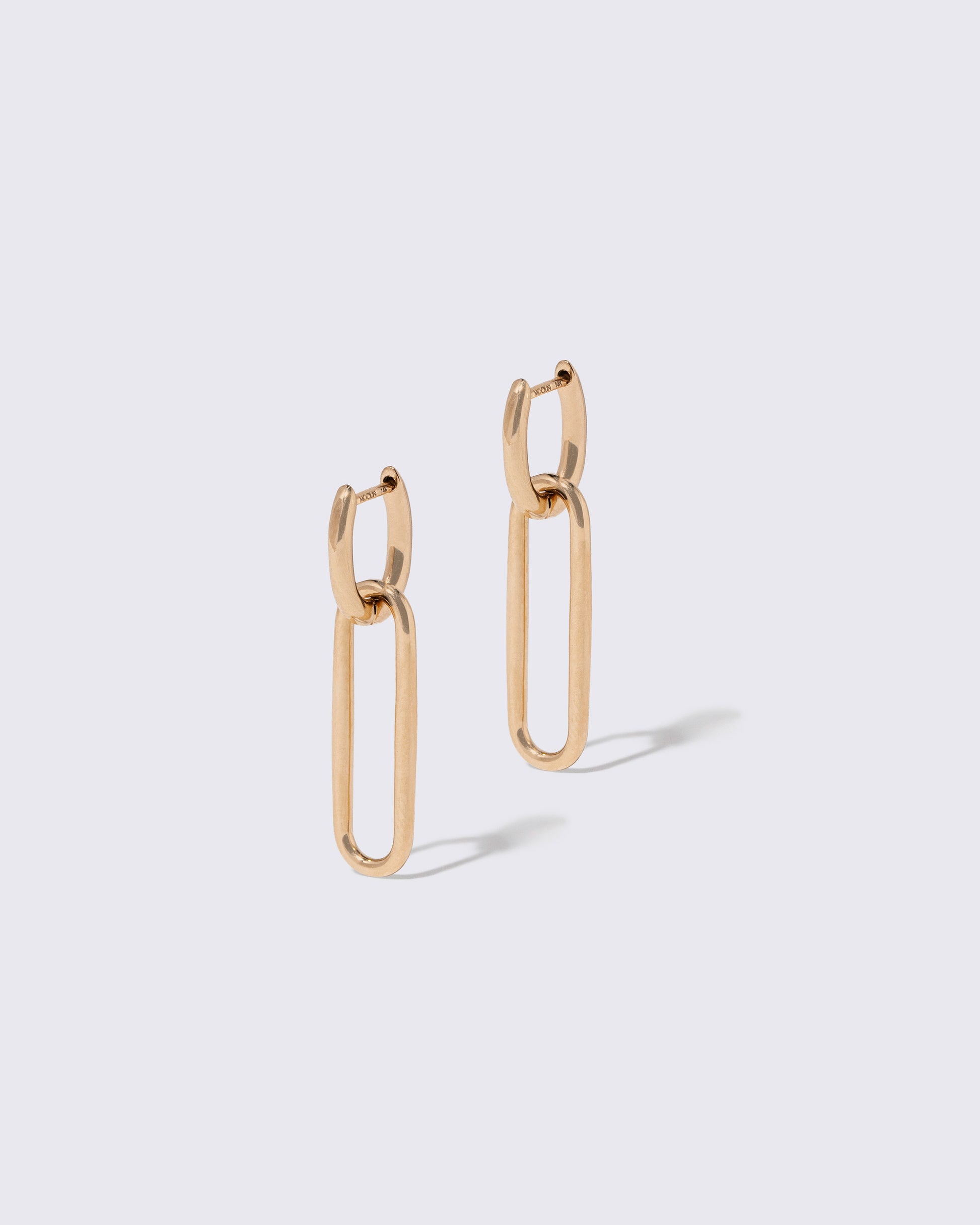 Link Huggie Hoop Earrings on light color background.