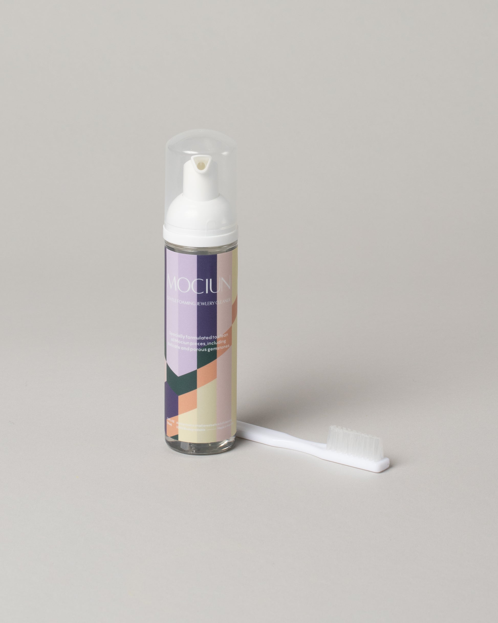 Mociun Jewelry Cleaner & Brush on light color background.