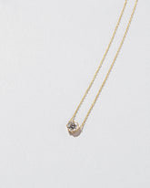 White Diamond Sun & Moon Necklace on light color background.