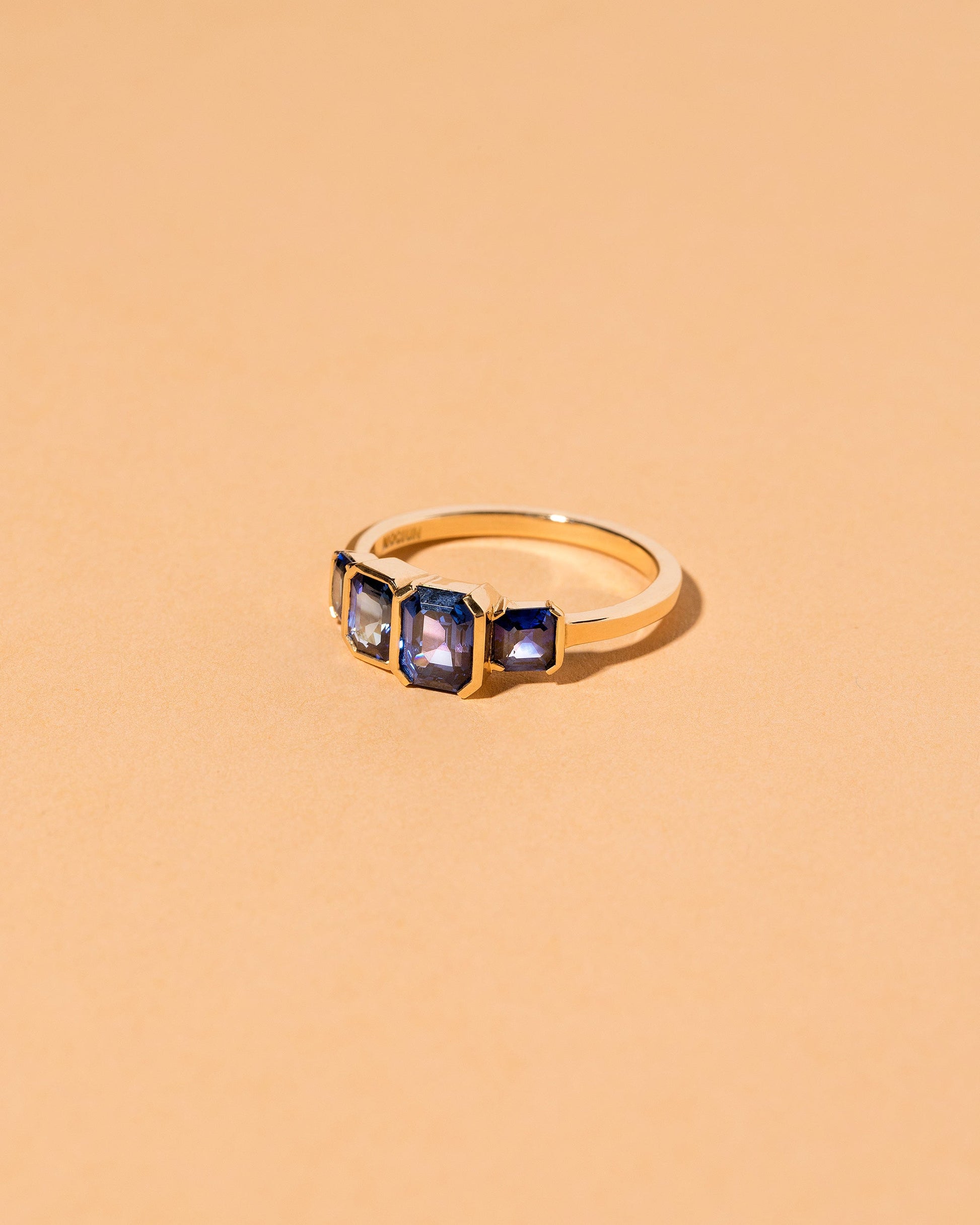 View from the side of the Geometric Sapphire Line Cluster Ring on light color background.