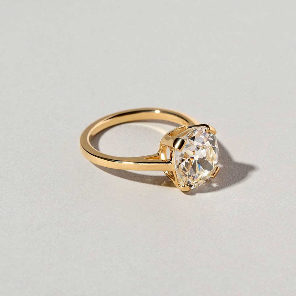 product_details::Closeup details of the Cushion Cut Diamond Solitaire Ring on light color background.