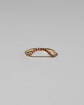 Gold Pavé Garnet Curve Band on light color background.
