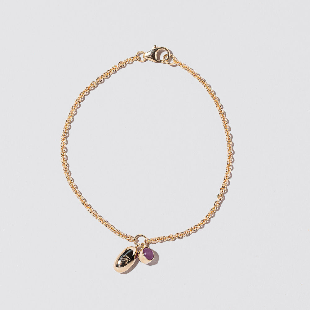 Bead Time Capsule Bracelet with Birthstone Charm on a light color background.