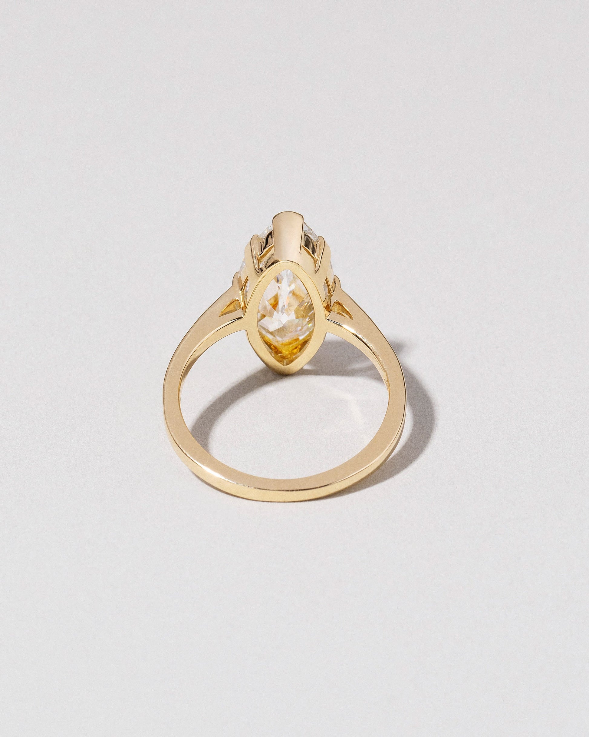 View from the back of the North-South Navette Diamond Solitaire Ring on light color background.