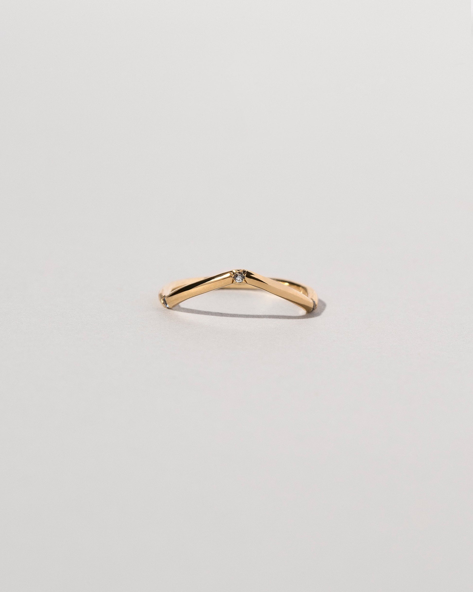 Gold Three Stone Blue Sapphire Low Peak Band on light color background.