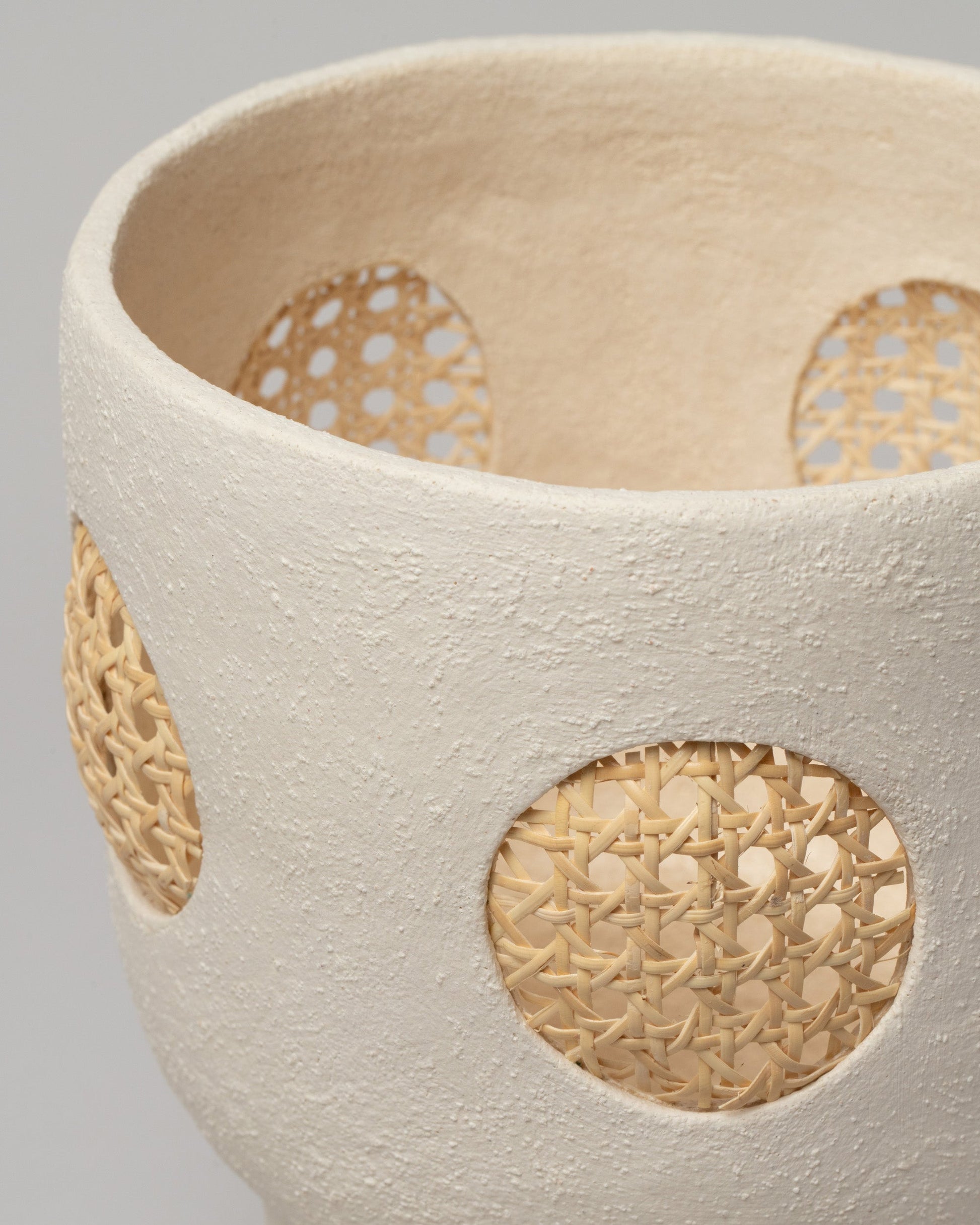 Closeup details of the Stephanie Phillips Cream Rattan Vessel on light color background.