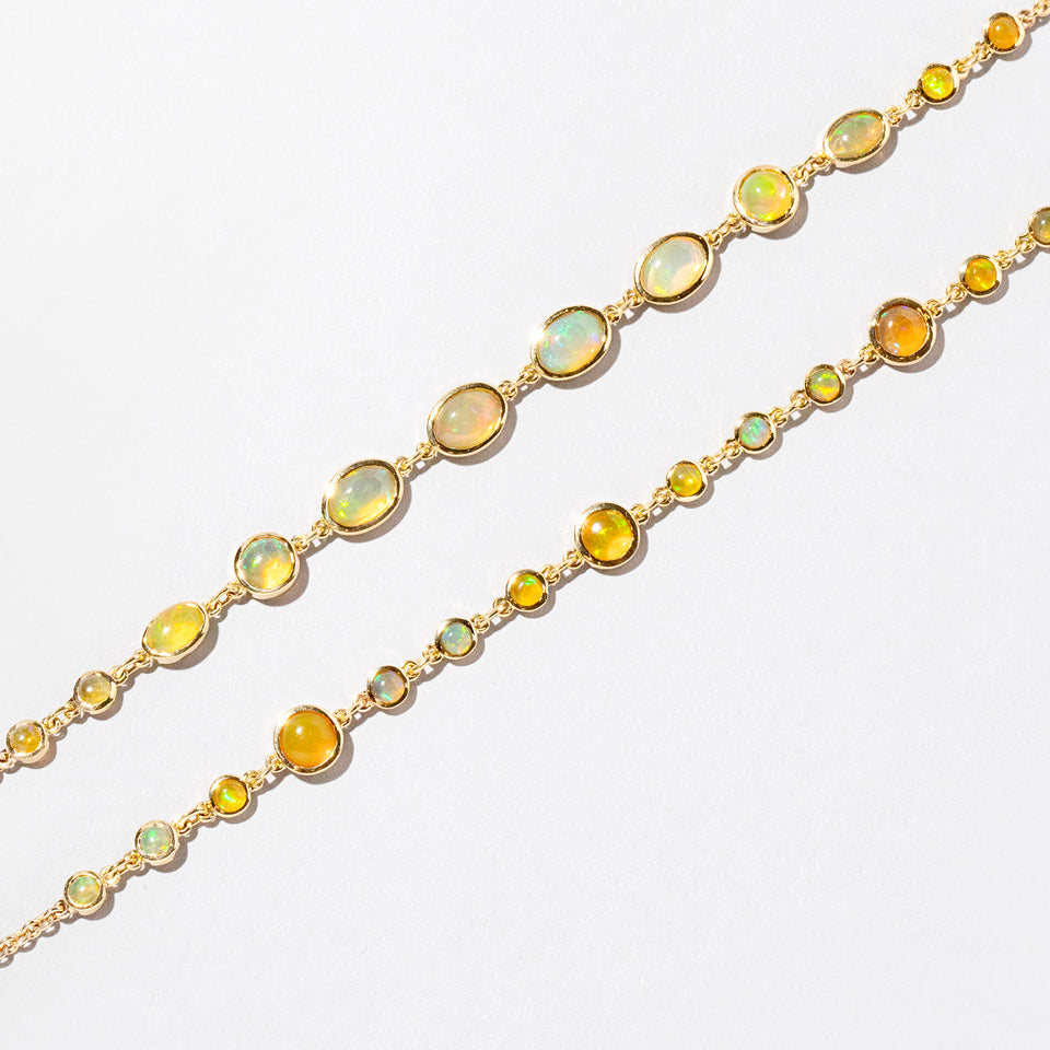 product_details::Ops Bracelet and Saturn Bracelet on light color background.