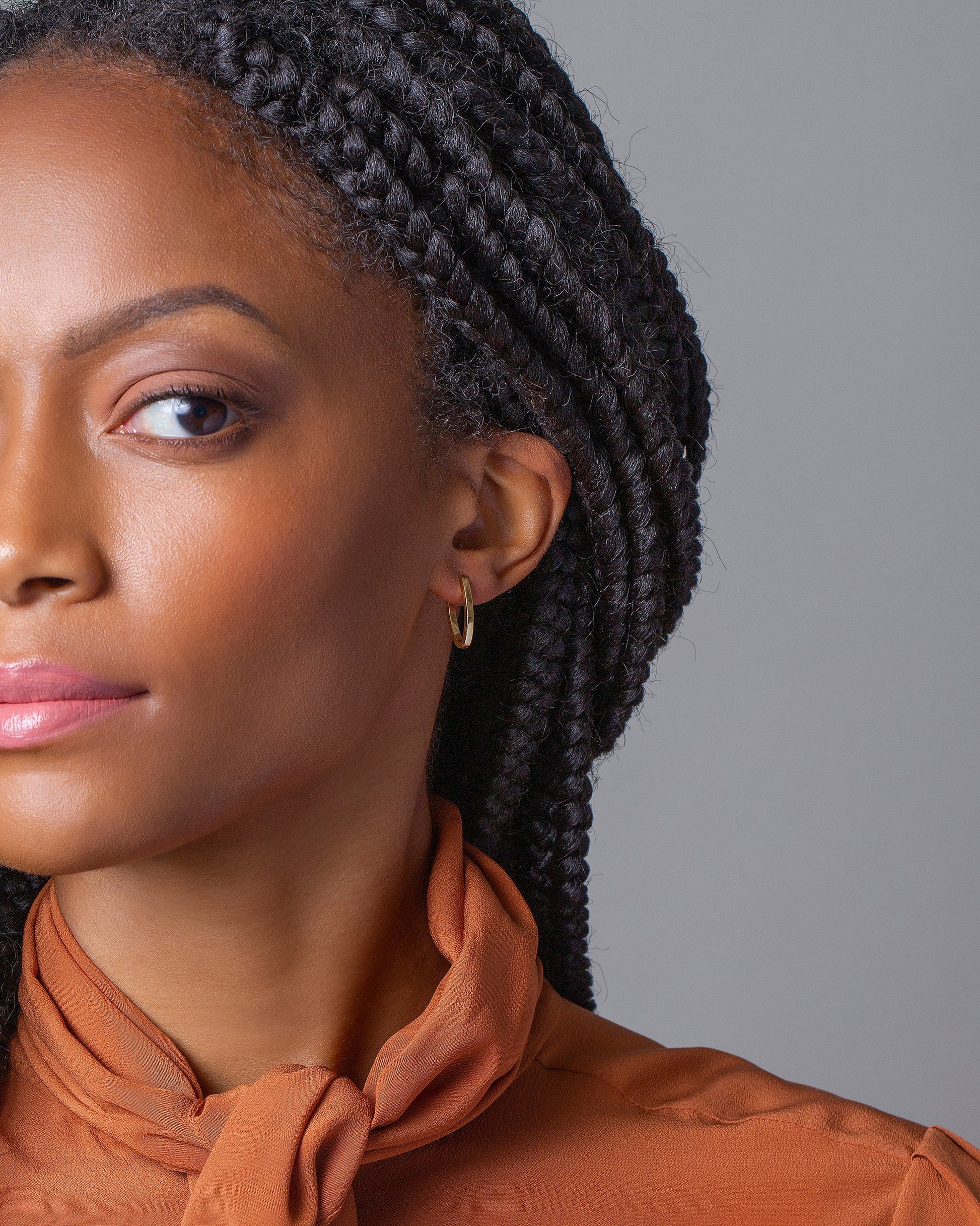 Gold Solid Tiny Loop Hoop Earrings on model.