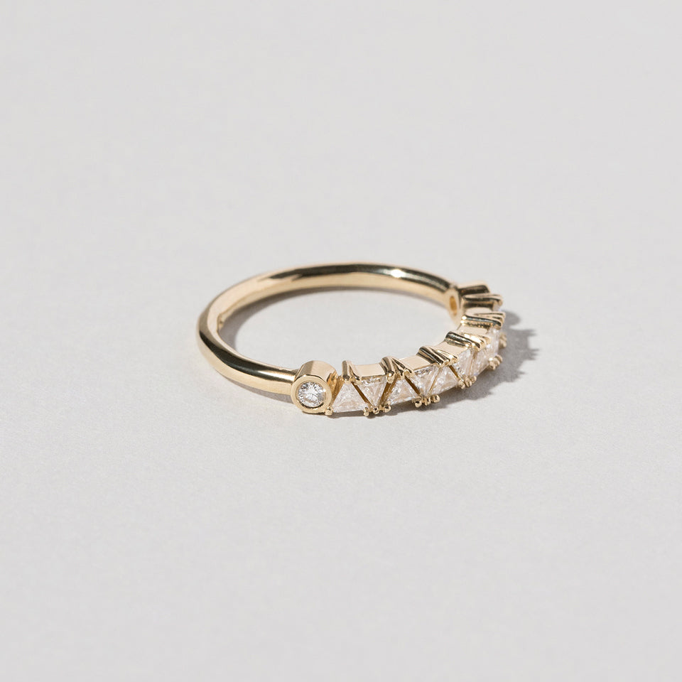 product_details::Closeup details of the Gold White Diamond Eleven Trillion Ring on light color background.