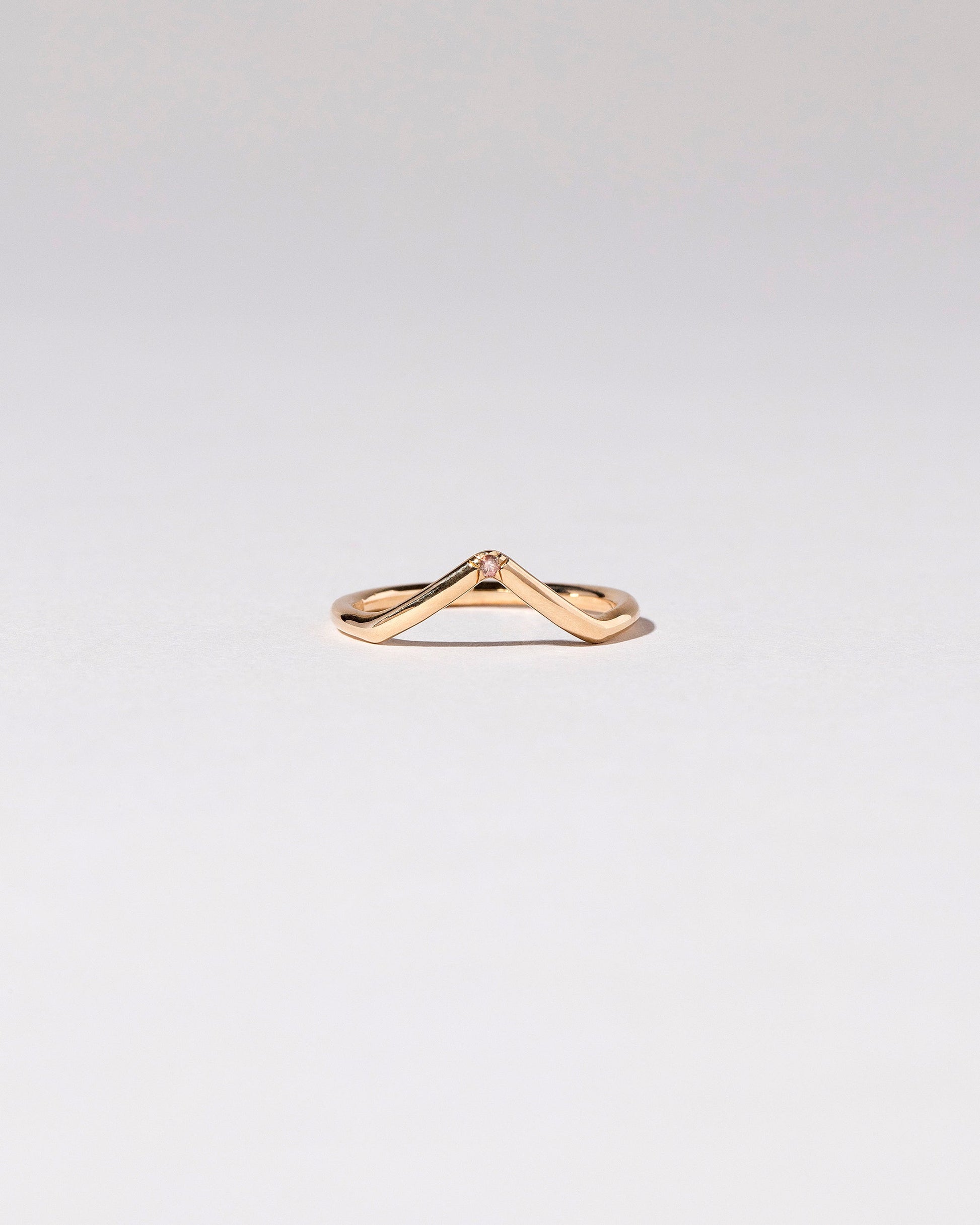 Gold Single Stone Peach Sapphire High Peak Band on light color background.