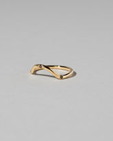 Closeup details of the Gold Three Stone Black Diamond Curve Band on light color background.