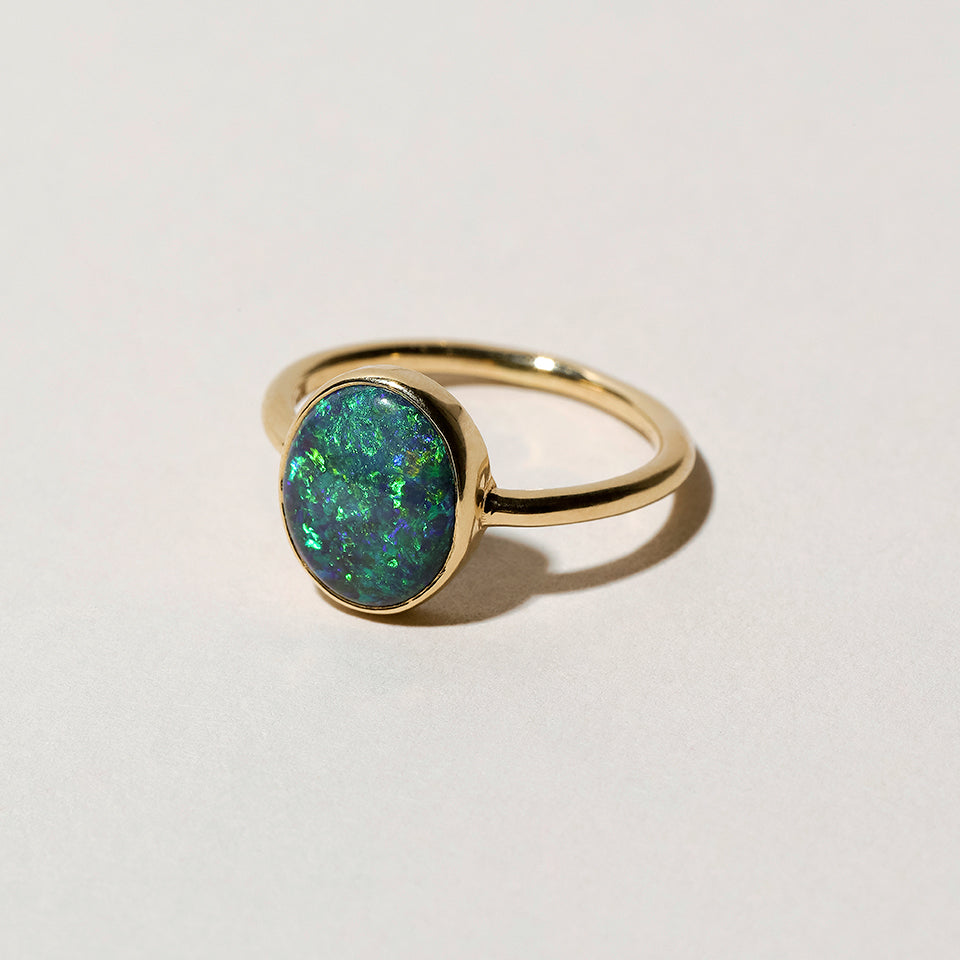 product_details::Closeup details of the Australian Black Opal Ring on light color background.