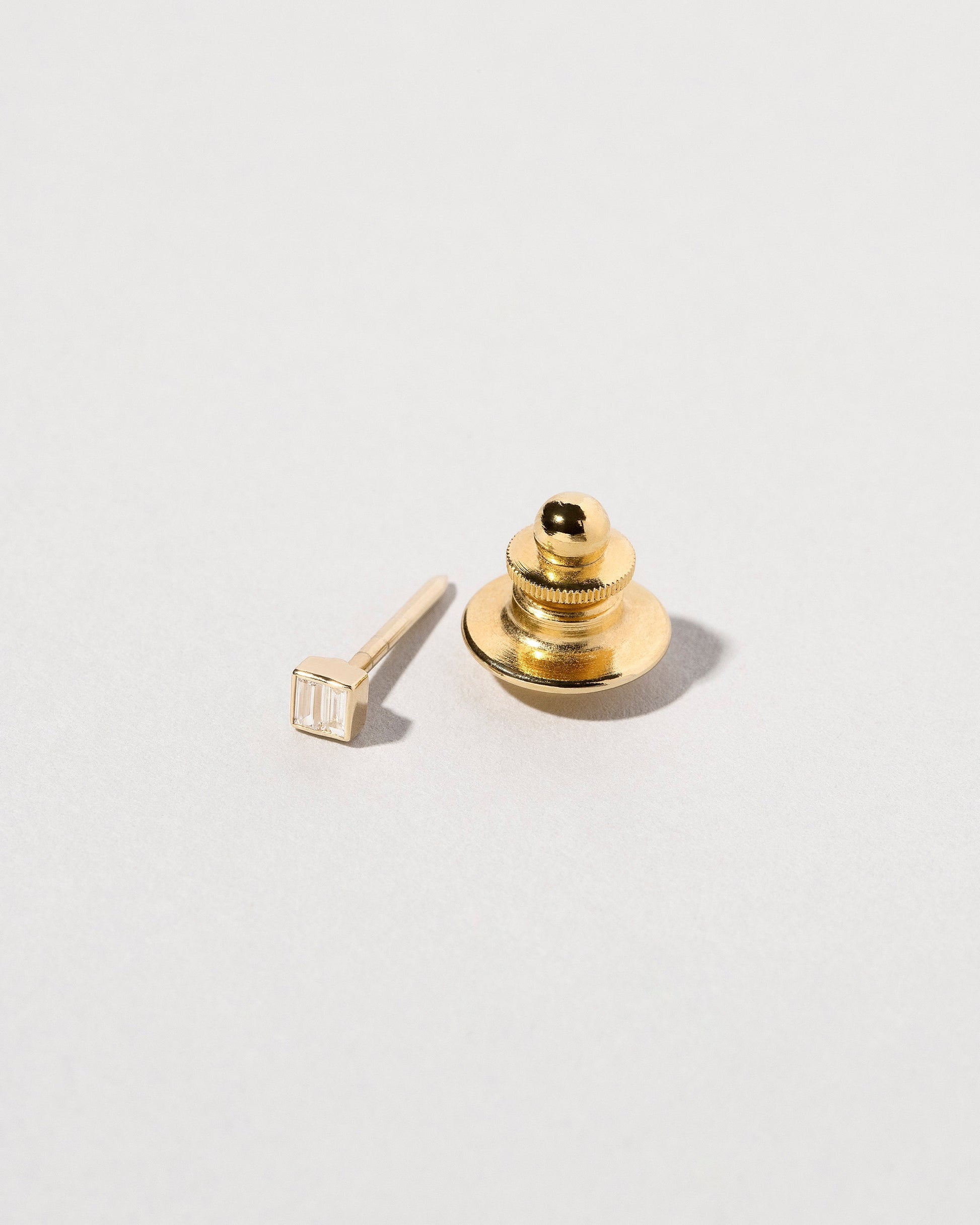 Closeup view of the Diamond Square Collar Pin on light color background.