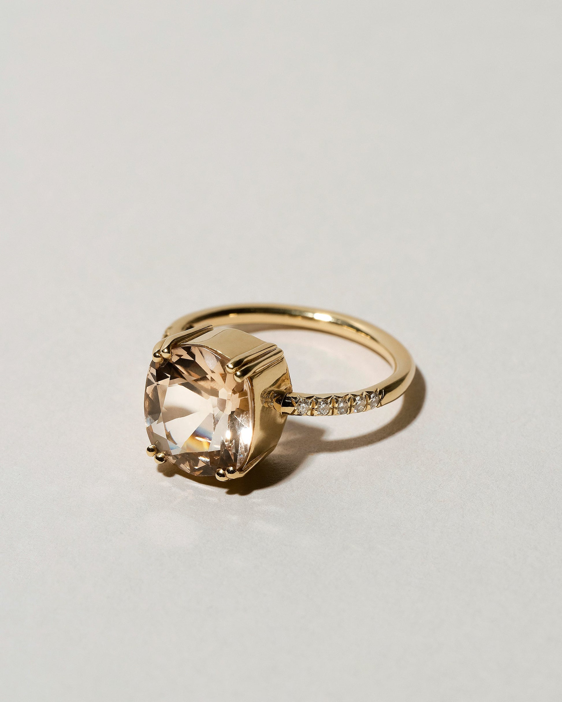 View from the side of the Morganite Solitaire Ring on light color background.