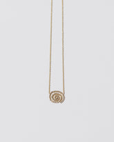 White Diamond Cycle of Rebirth Necklace on light color background.
