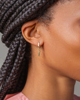 Gold Snack Hoop Earrings with Solid Snap Pea Charm on model.