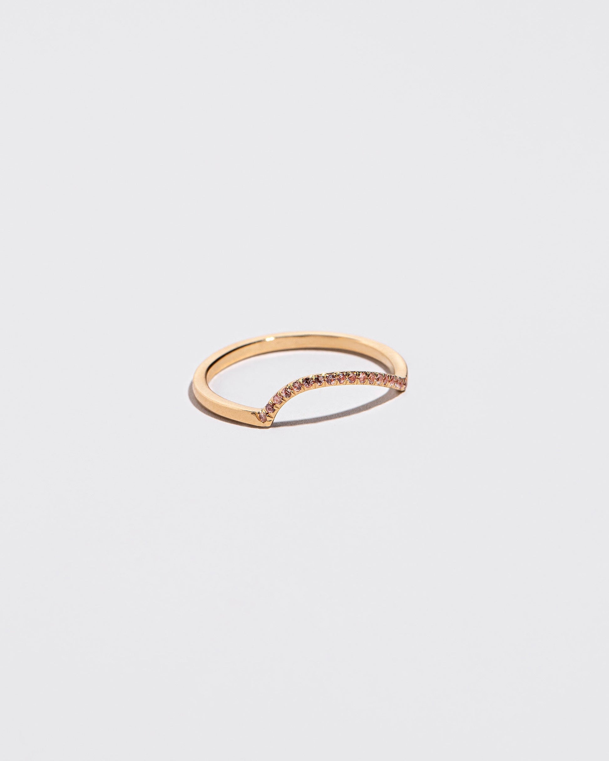 Gold Pavé Peach Sapphire Left Slump Band on light color background.