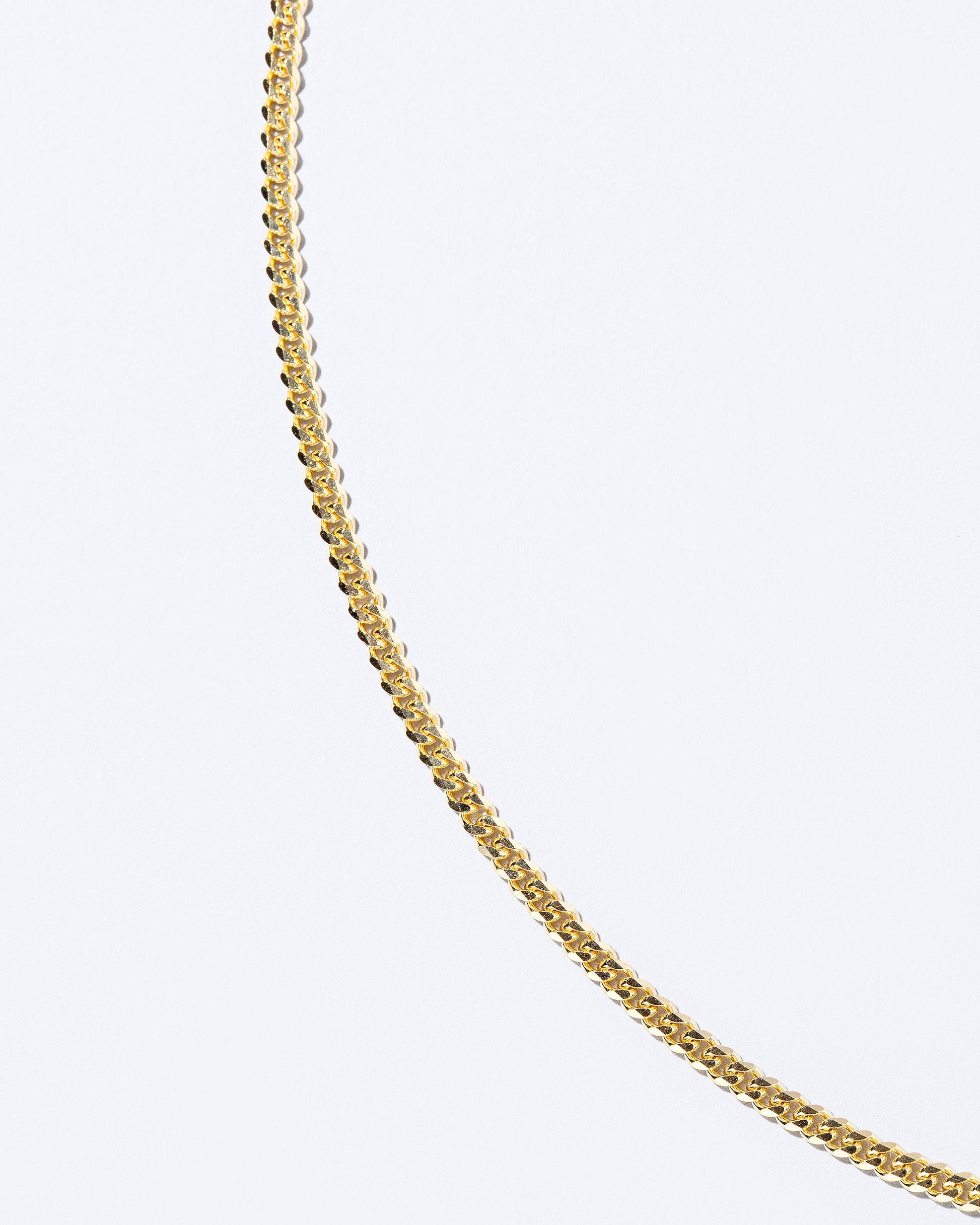 Closeup details of the 2.4mm Curb Chain Necklace on light color background.